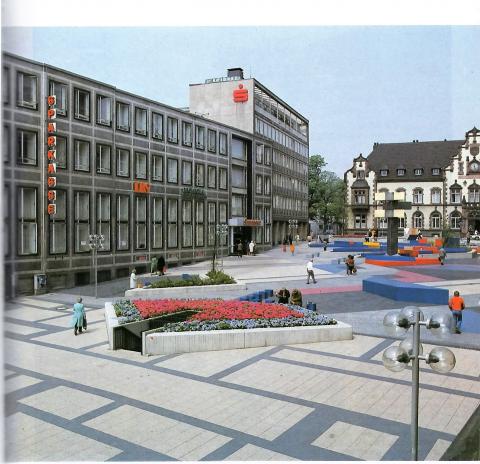 Hajek, Otto Herbert: Brunnen mit Platzgestaltung/ Synagogenplatz (damals: Viktoriaplatz), Blick von der Schloßstraße auf ehem. Sparkasse (dort seit 2009: MedienHaus), © VG Bild-Kunst, Bonn 2019; Foto: Kunstmuseum Mülheim an der Ruhr 1985.