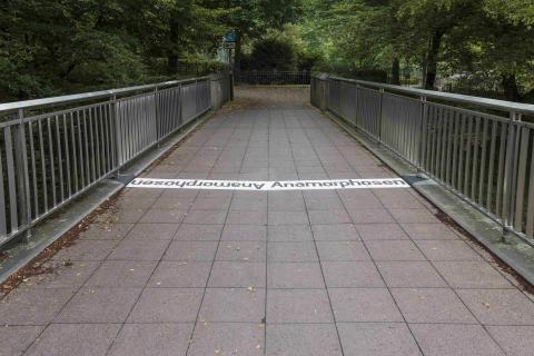 Nekes, Werner: Kegelanamorphosen, Schirftzug auf der Kfar-Saba-Brücke, Zustand 2020; Foto: Kunstmuseum Mülheim an der Ruhr/ Ralf Raßloff, Copyright VG Bild-Kunst 2020.