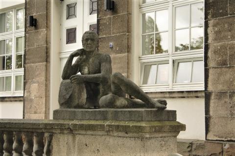 Janssen, Ulfert: Liegefigur an Treppe, Haupteingang Max-Planck-Institut, &quot;Geistige Arbeit&quot;; Foto: Kunstmuseum Mülheim an der Ruhr 2016. 